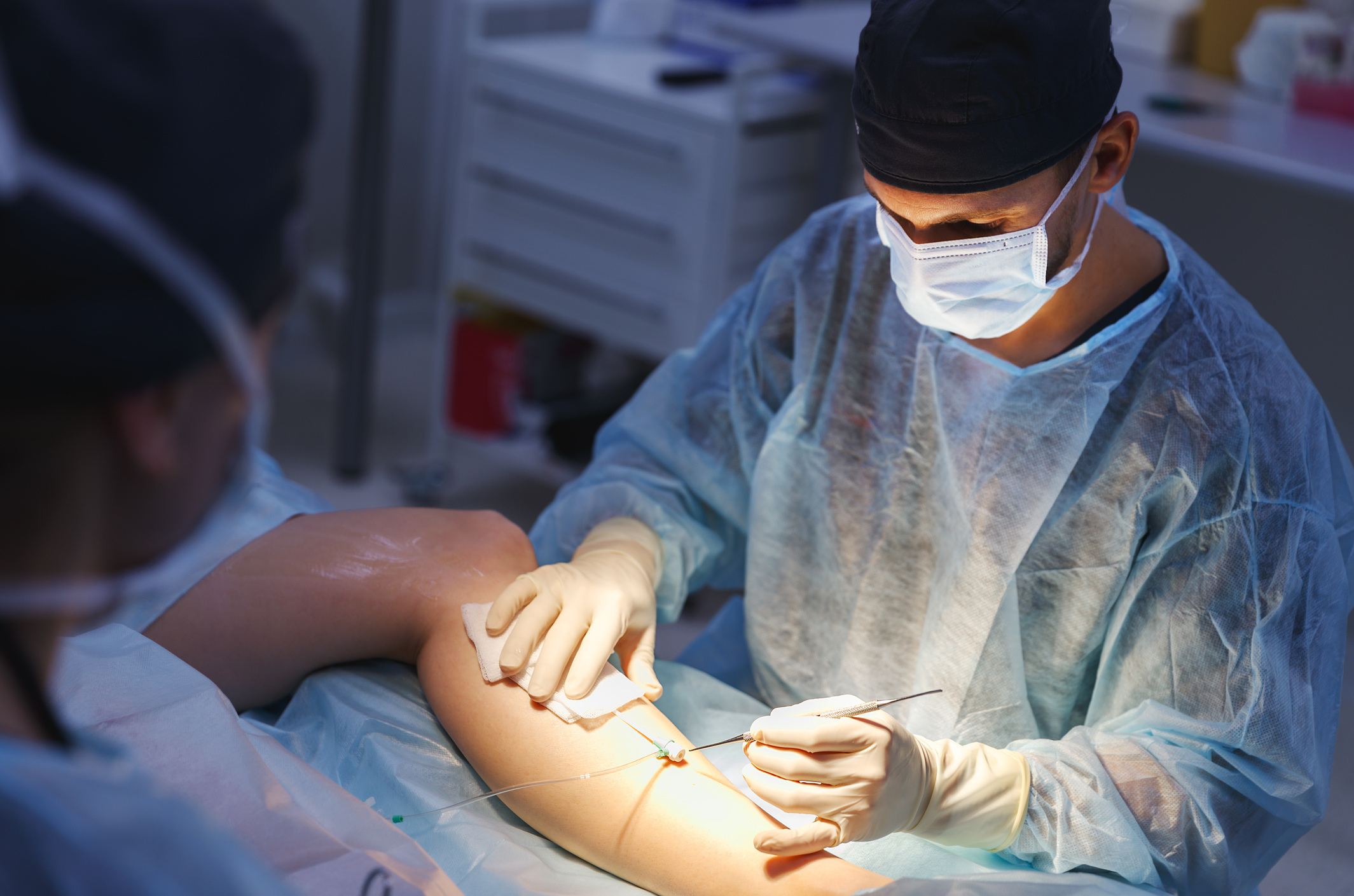 doctor and an assistant in the operating room for surgical venous vascular surgery clinic